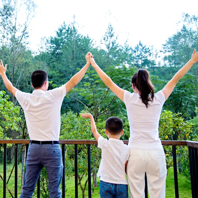 Happy young family together enjoying green nature.