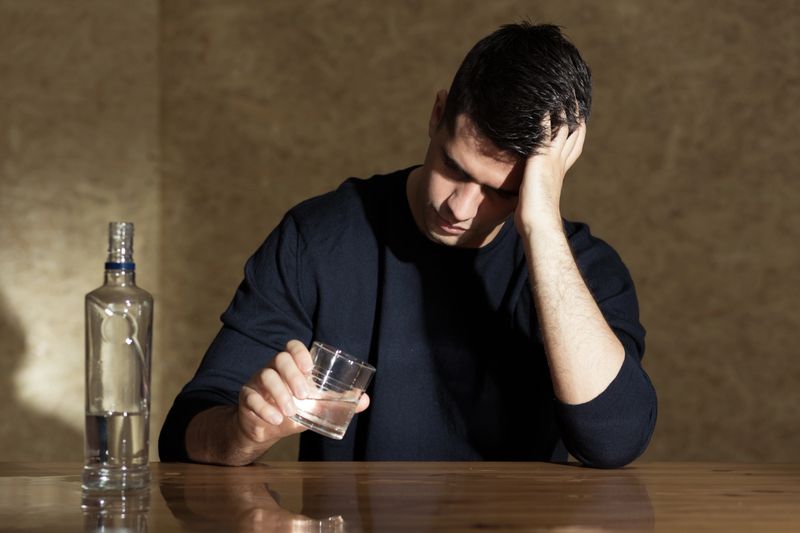 Young man drinking vodka in the glass