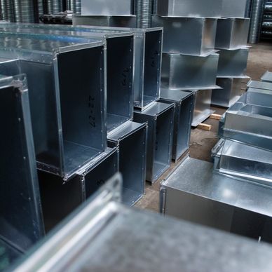 Stacked rectangular metal ducts in an industrial setting.