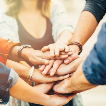 Hands stacked together in a symbol of teamwork.