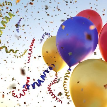 Colorful balloons and confetti in the sky.
