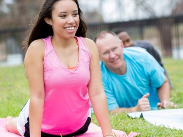 Young woman and others exercising outdoors.