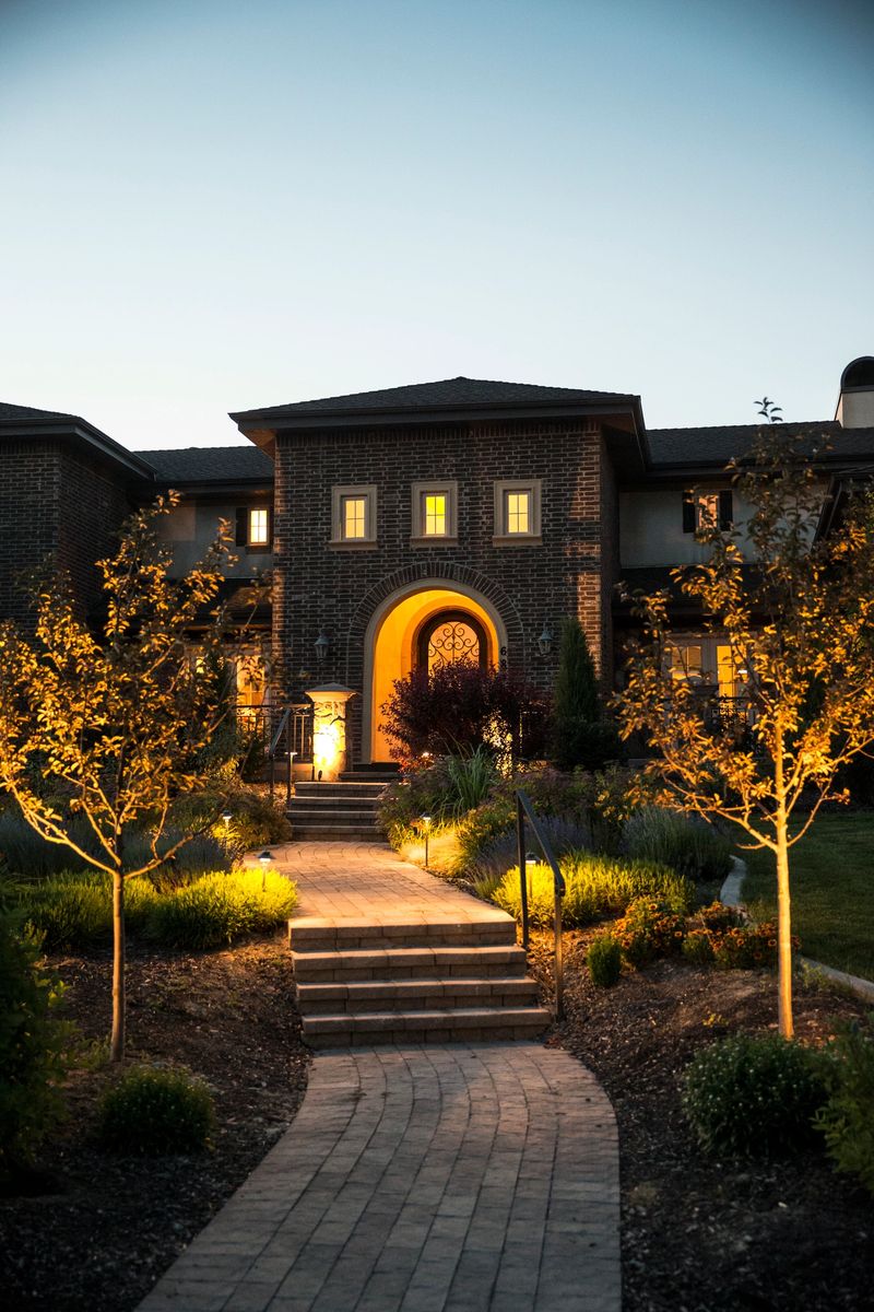 Entrance to a modern brick home in Utah, USA.  Entrance has brick pavers and landscape to either side.