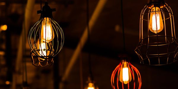 Warm glowing vintage cage pendant lights in a dim setting.