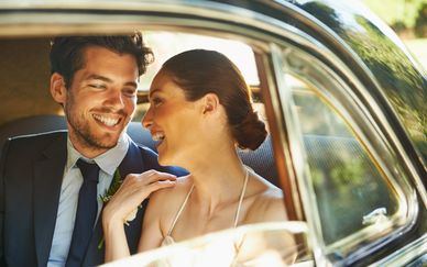 Happy couple smiling inside a car.