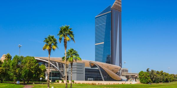 Modern building and tall tower under clear blue sky.