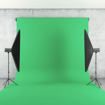 A green screen backdrop with two studio lights in a photography setup.