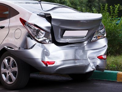 Silver car with significant rear-end damage