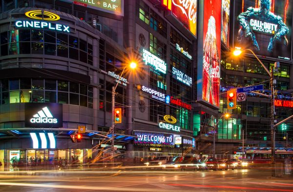 
This is a vibrant night-time shot of a busy city street, likely a major entertainment. 
