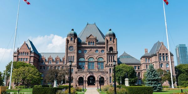 Historic government building with clock towers under blue sky.