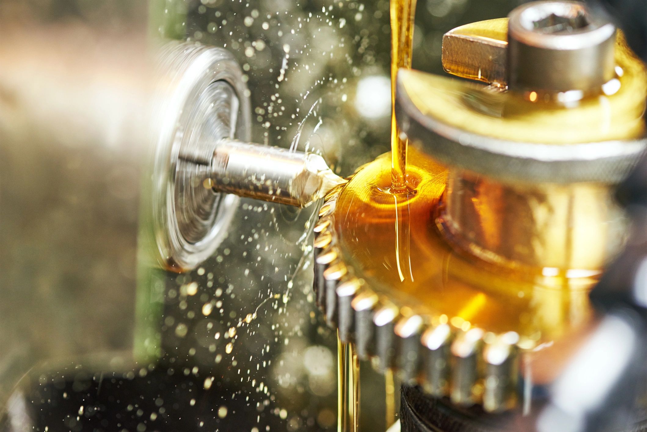 Cooling lubricant on a metal gear during machining.