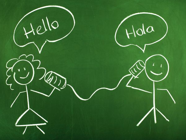 Chalk-drawn stick figures on a blackboard using tin can phones saying 'Hello' and 'Hola'.