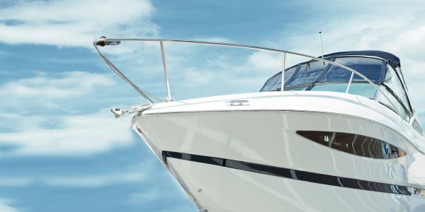 Front view of a white yacht against a blue sky.