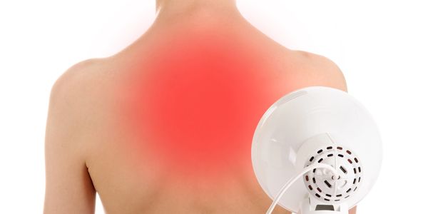 Person using heat therapy on upper back pain area.