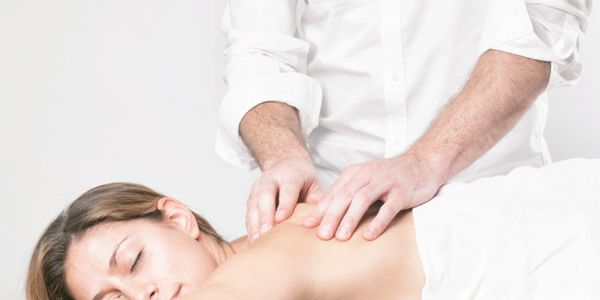A woman receiving a relaxing back massage from a therapist.