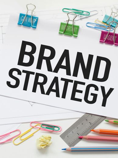 Paper with 'Brand Strategy' text surrounded by stationery.