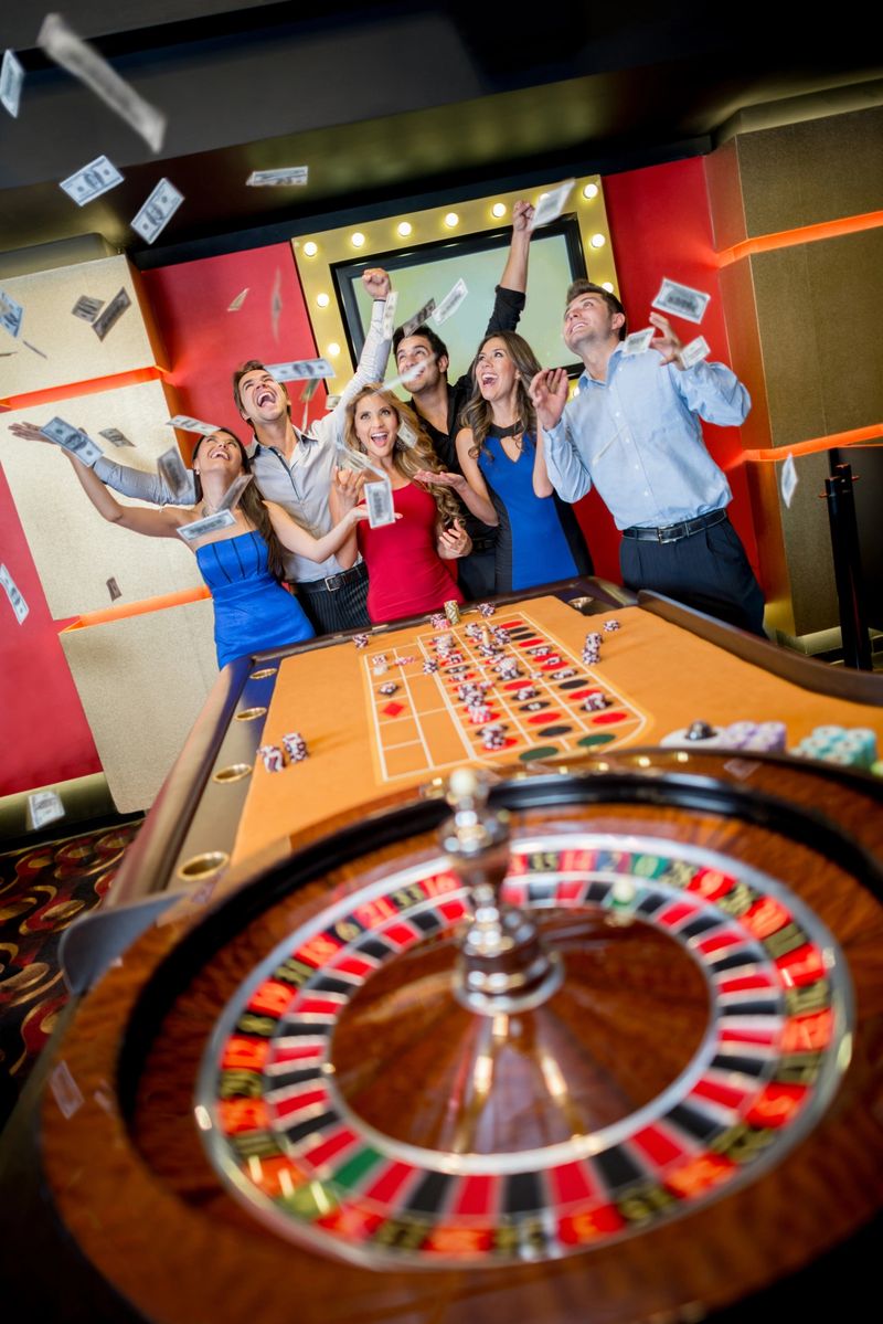 Happy group of people winning money at the casino