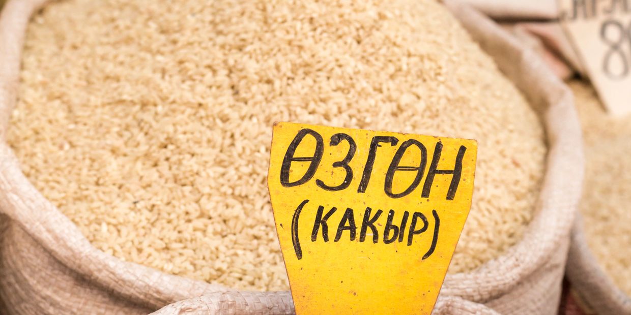 A large sack of rice with a yellow label in a market.