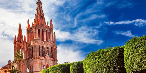 Historic pink church with a vibrant blue sky.