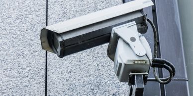 Close-up of a security camera mounted on a building exterior.