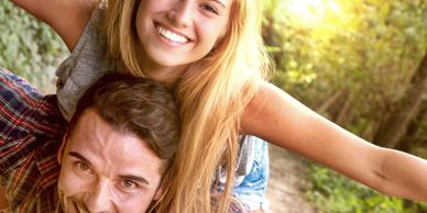 Young couple smiling and having fun outdoors on a sunny day.