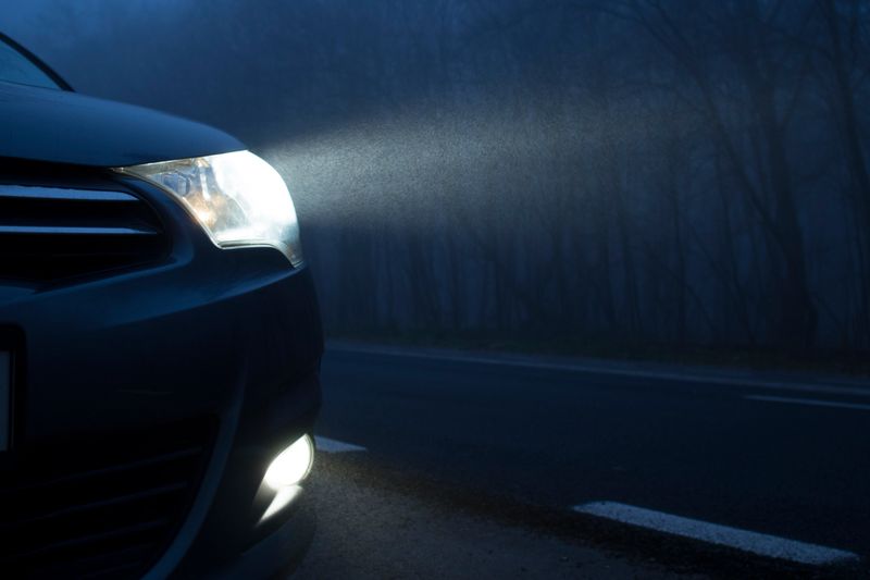 Professional auto detailer applying ceramic coating with precision tools