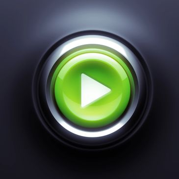 A shiny green play button on a dark background.