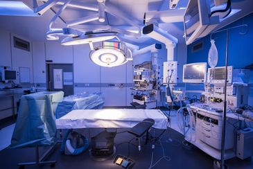 A modern operating room equipped with surgical lights and medical monitors.