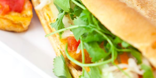 Close-up of a fresh sandwich with cilantro and vegetables.