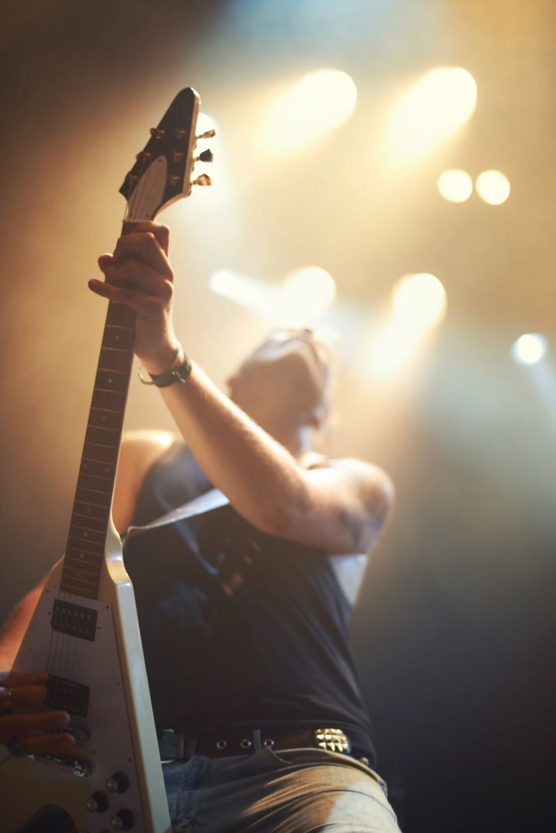 A guitarist playing his heart out beneath the strobe lights. This concert was created for the sole purpose of this photo shoot, featuring 300 models and 3 live bands. All people in this shoot are model released.