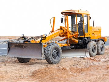 Yellow construction grader on a dirt site.