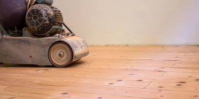 A floor sanding machine on a wooden floor.