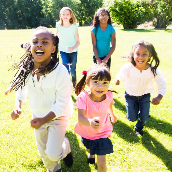 Group of happy children running outdoors on a sunny day.
