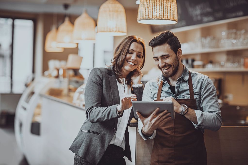 Man and woman looking at laptop in cafe