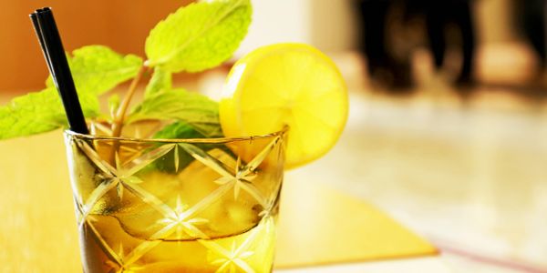 Refreshing iced tea with lemon and mint leaves in a glass.