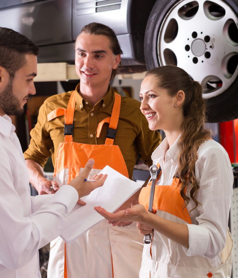 portrait two troubleshooters showing fixed car to cheerful client