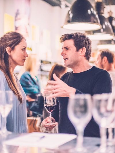 Man and woman engaged in an intense conversation at a social gathering.