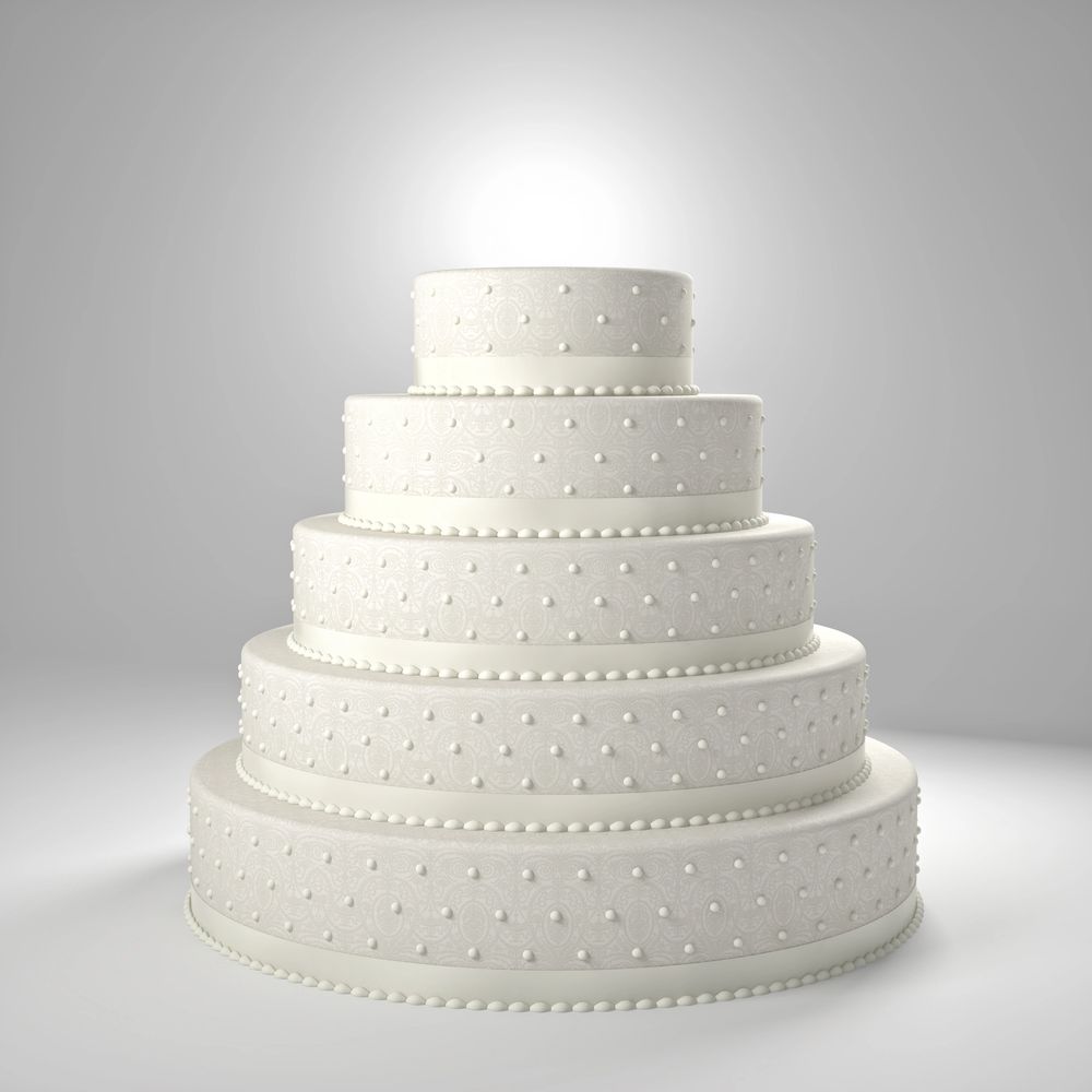Elegant five-tier white wedding cake with intricate lace-like patterns and pearl decorations.