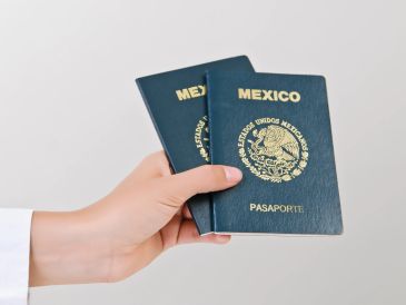 Mano sosteniendo dos pasaportes mexicanos.