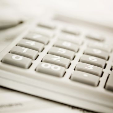 Close-up of gray calculator keys with numbers and symbols.