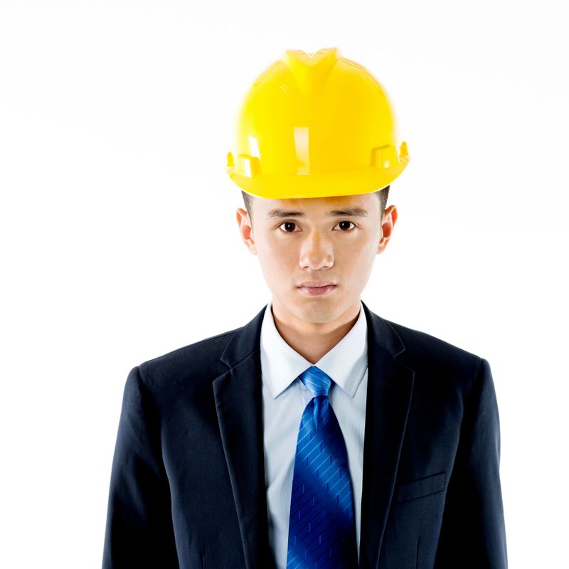 Young engineer with helmet against white background.