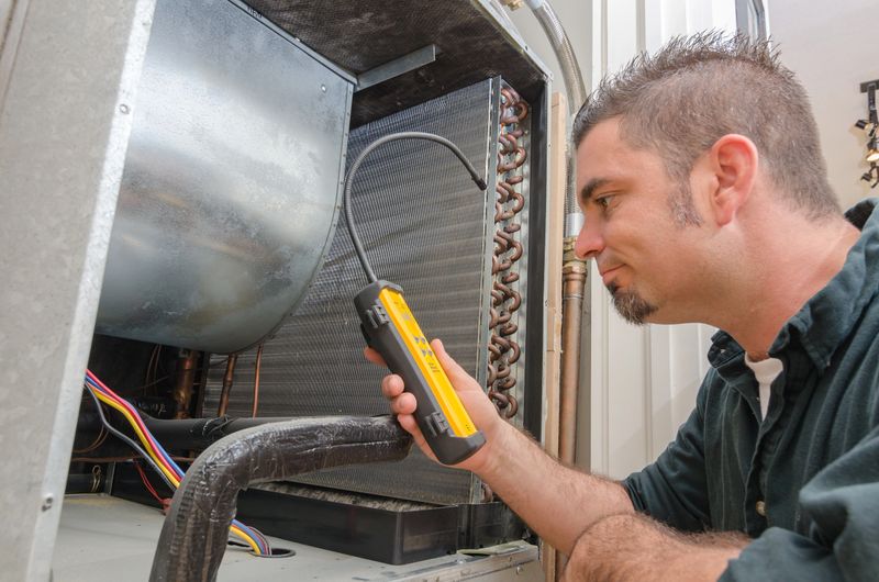 An Hvac technician searching for a refrigerant leak on an evaporator coil.