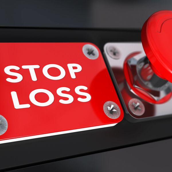 Red emergency stop loss push button on a black panel.