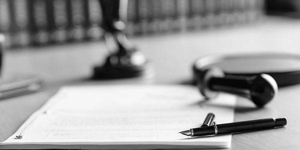 Law documents, gavel, and pen on a desk.