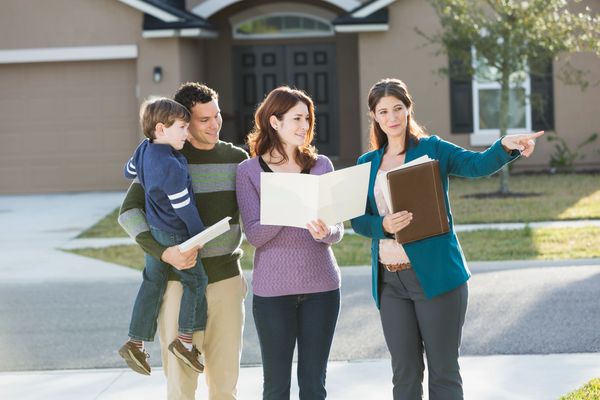 Real estate agent showing a family a house.