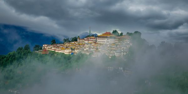 A misty hilltop monastery under cloudy skies.