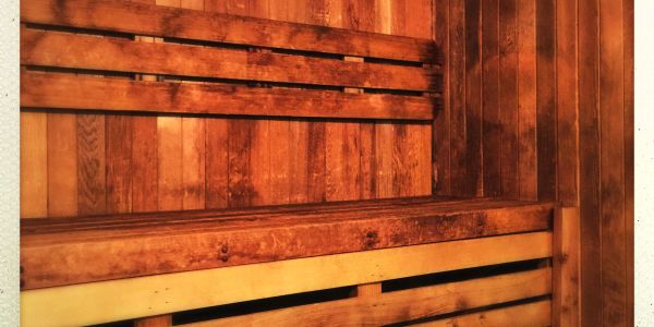 Wooden sauna interior with bench seating and warm lighting.