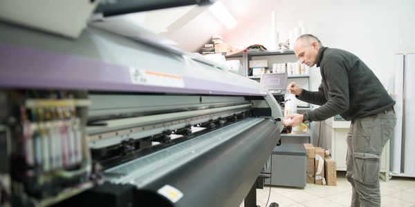 Print operator working at a wide-format printer.