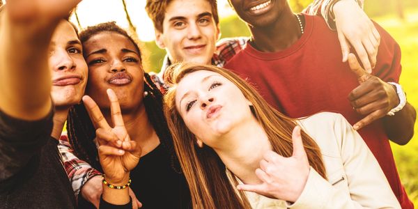 Group of diverse friends taking a fun selfie outdoors.