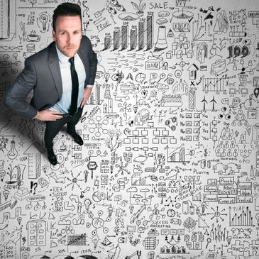 Businessman standing on a floor covered with complex business strategy doodles.